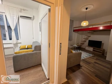 View from the hallway into the living room with a sofa and a mezzanine. - image 8