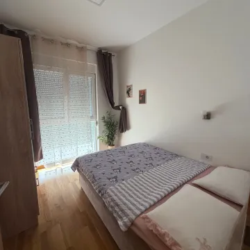Namještena spavaća soba sa bračnim krevetom i izlazom na balkonska vrata. - image 5