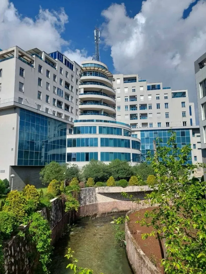 Exterior of a modern residential building with large glass surfaces next to a river.