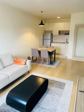Open-plan living room with dining area and kitchen. - image 3
