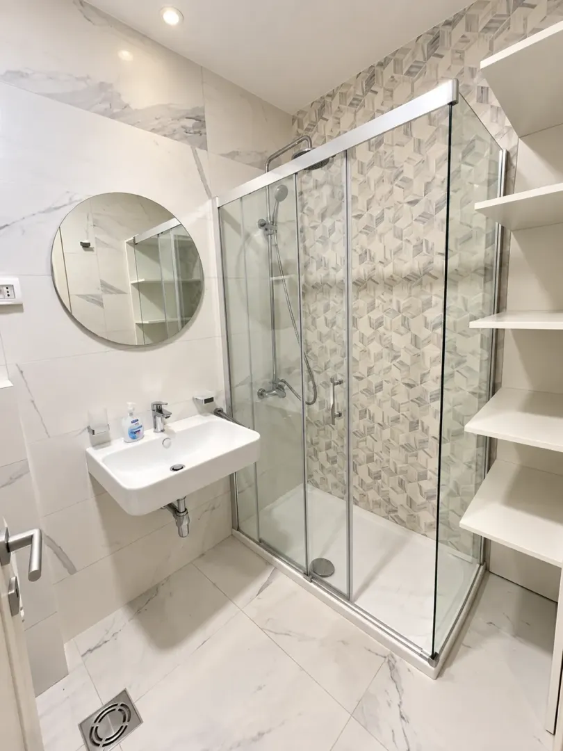 Modern bathroom with a shower cabin, sink, and mirror.