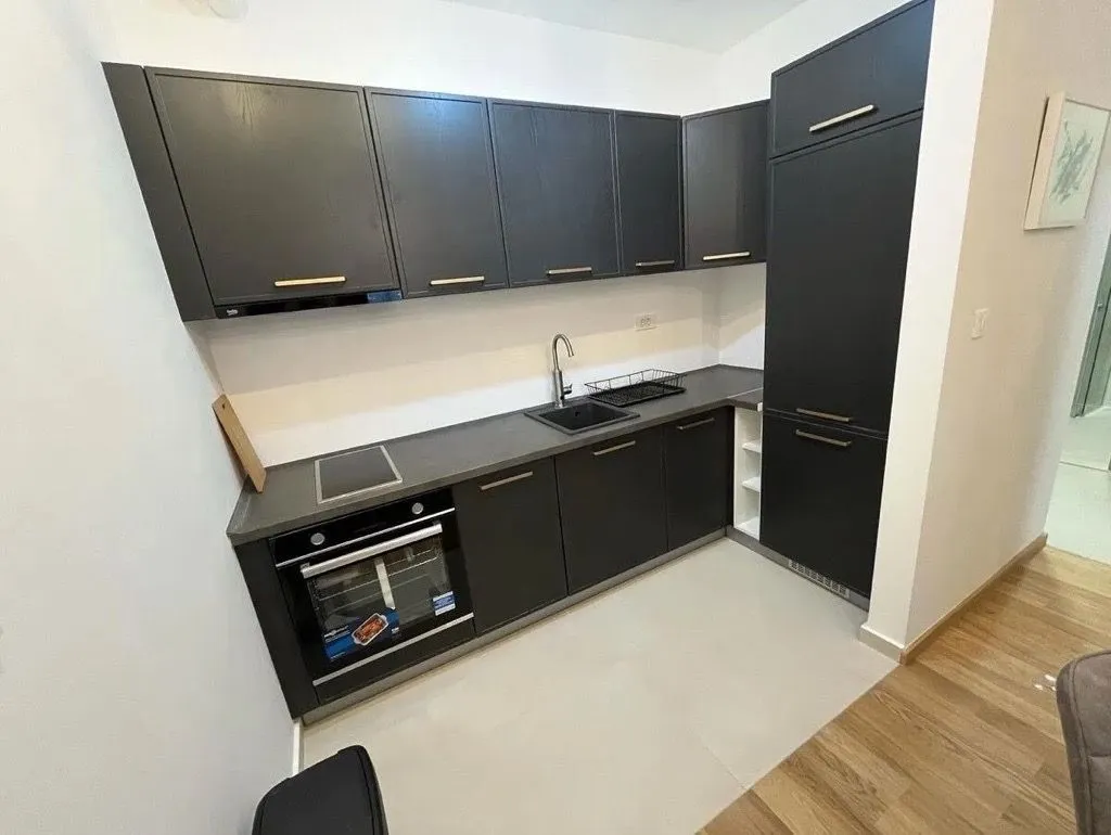 Modern kitchen with dark cabinets and built-in appliances.