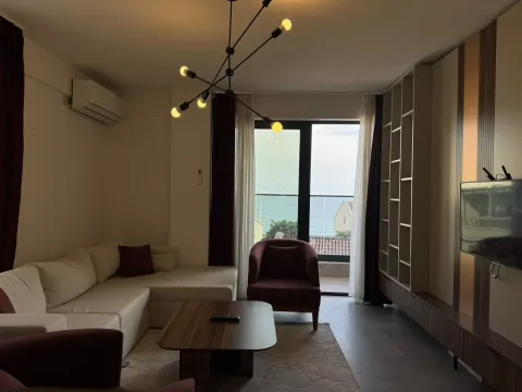 Living room with sofa, TV, and sea view. - image 2