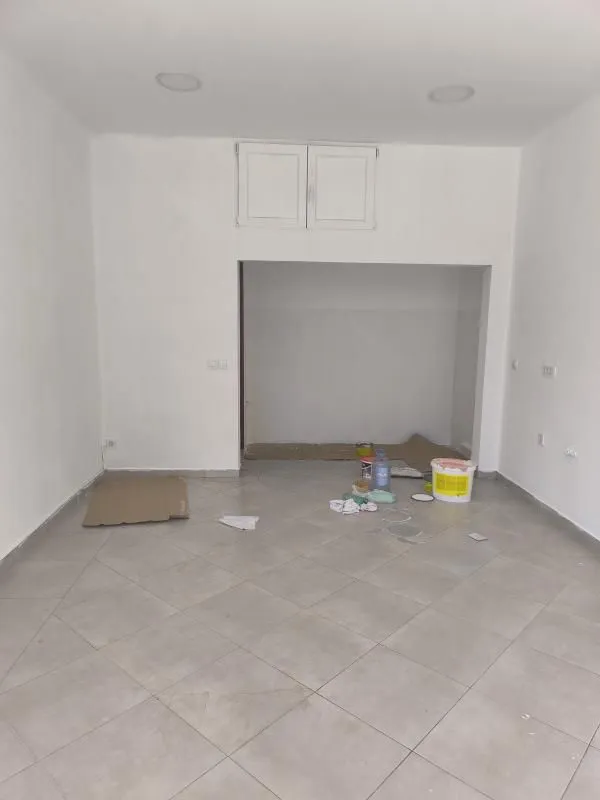 Empty room with ceramic floor tiles and painted walls.