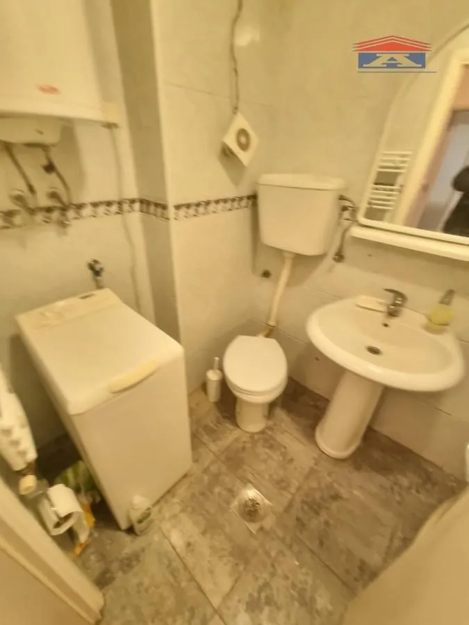 Manje kupatilo sa sanitarijama, umivaonikom i veš mašinom.