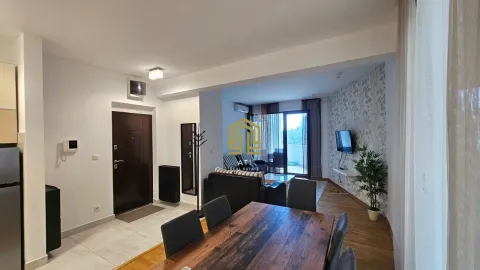 Living room with dining area and entrance space in the apartment. - image 5
