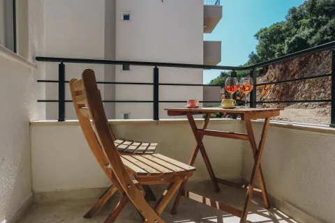Namješten balkon sa drvenim stolom i stolicama. - image 11
