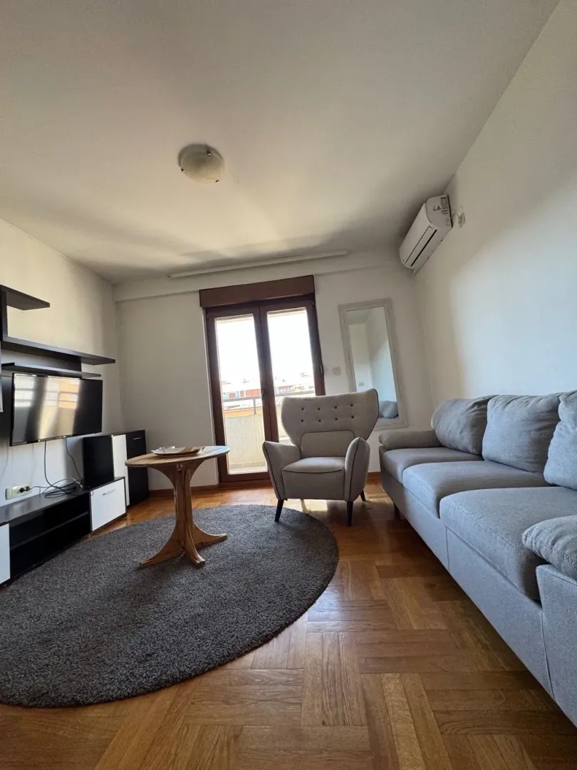 Living room with a sofa, armchair and TV unit.