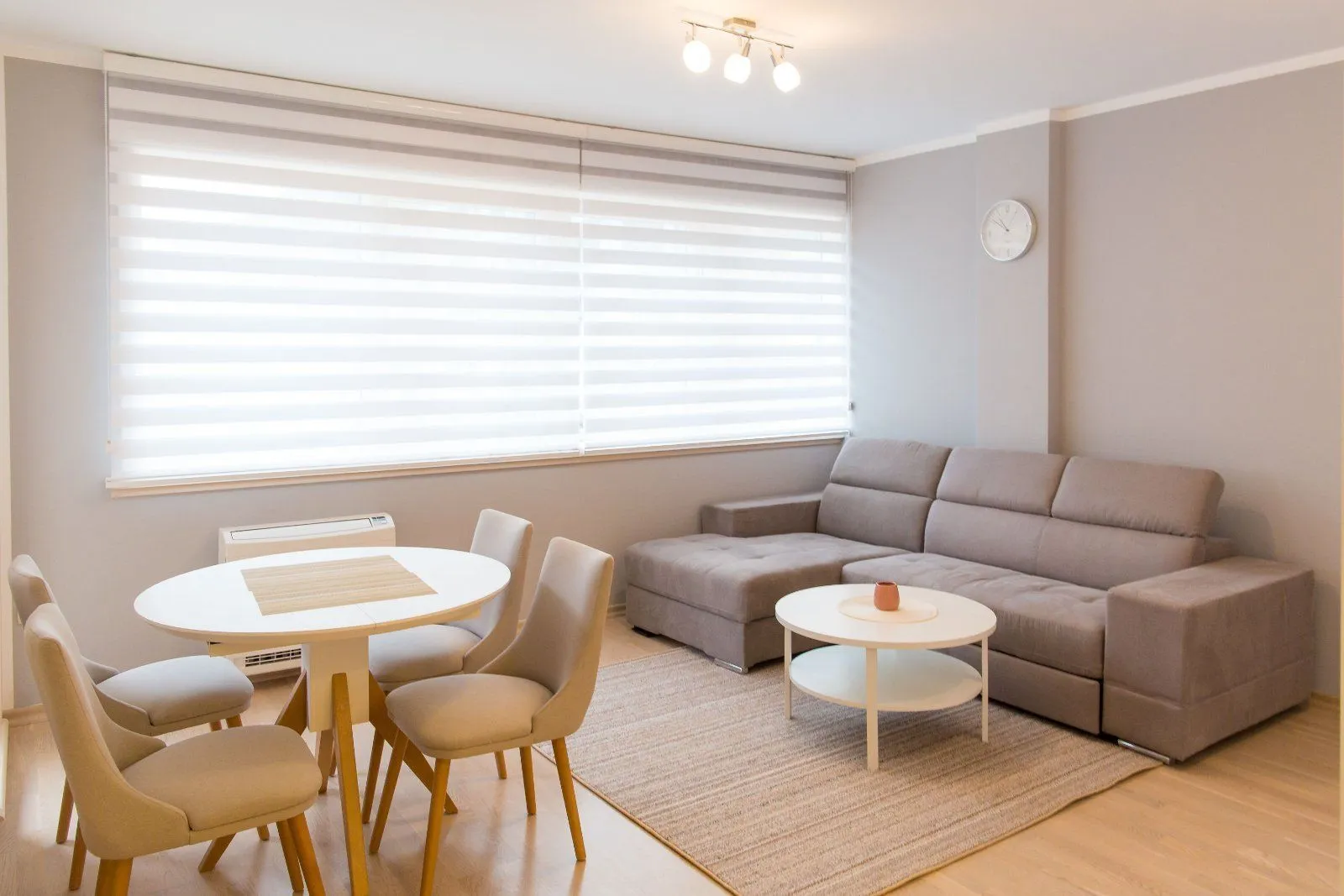 Living room with a sectional sofa, dining table and chairs.