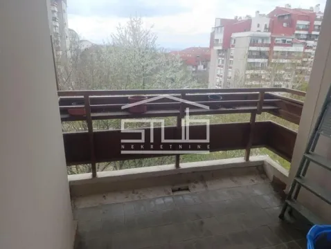 View from the balcony towards surrounding buildings and trees. - image 10