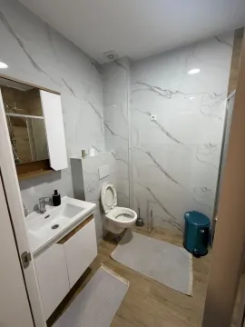 Savremeno opremljeno kupatilo sa bijelim pločicama i sanitarijama. - image 4