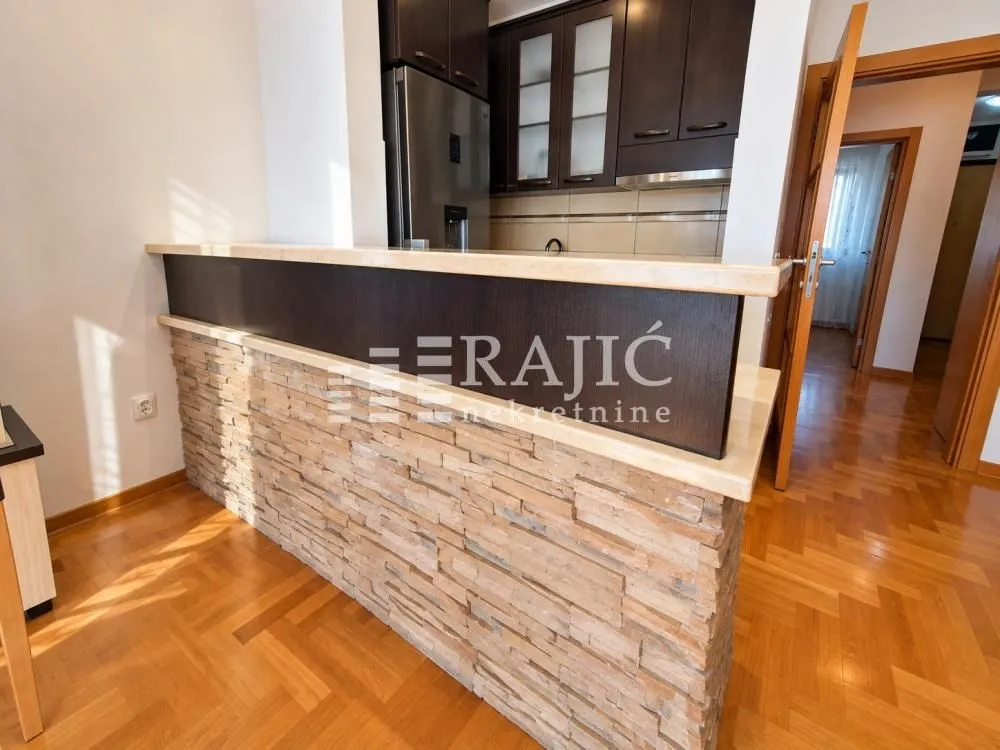 Modern kitchen with a bar counter and wooden elements.