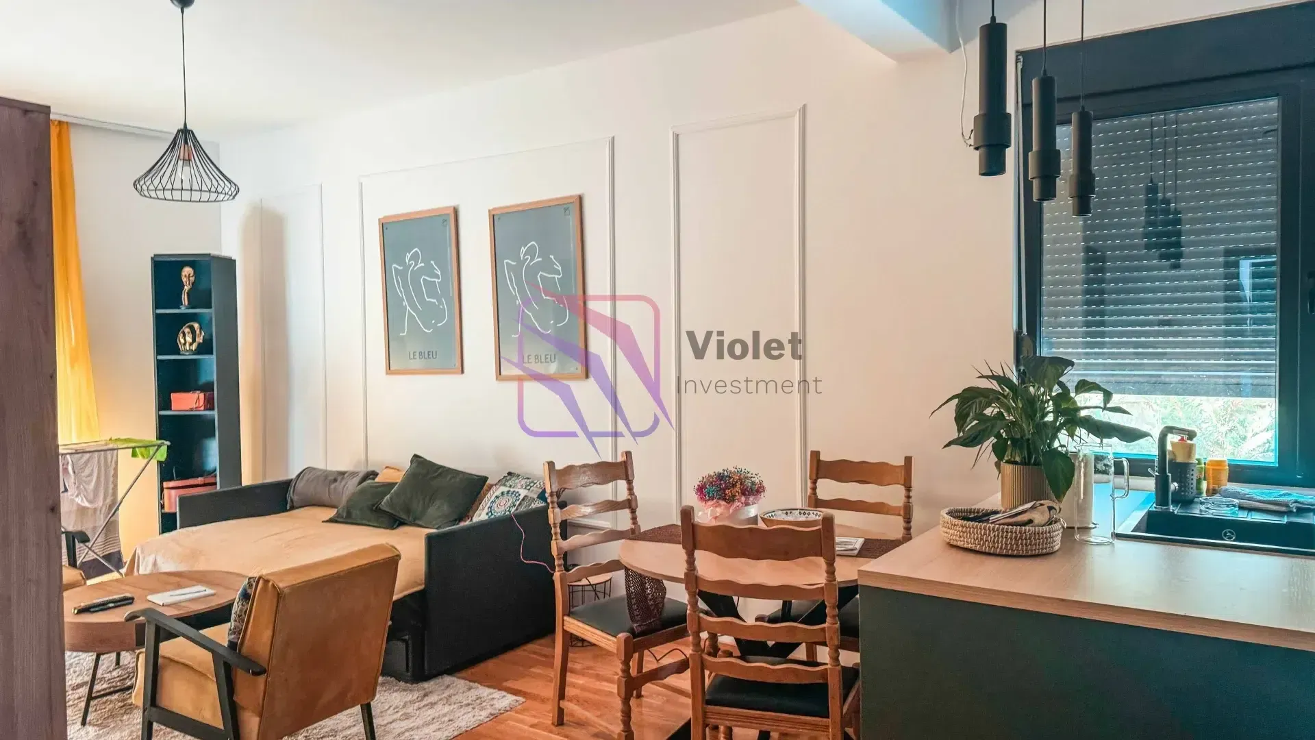 Living room with a seating area, dining table, and kitchen corner.