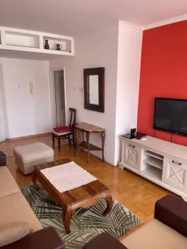 Bright living room with furniture and a red accent wall. - image 3