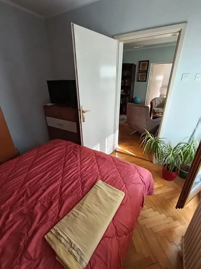 Spavaća soba sa bračnim krevetom i pogledom na hodnik i susednu prostoriju.