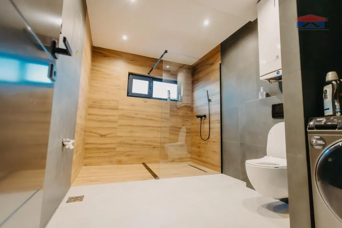 Moderno opremljeno kupatilo sa tuš kabinom i wc šoljom.