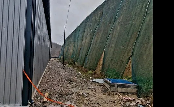 View of the exterior part of the building with a protective net and access pathway.