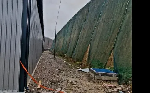 View of the exterior part of the building with a protective net and access pathway. - image 6