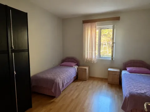 Bedroom with two single beds, a wardrobe, and a window. - image 8