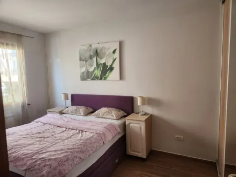Namještena spavaća soba sa bračnim krevetom, noćnim stočićima i slikom na zidu. - image 3