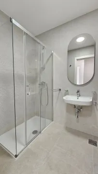 Modernly equipped bathroom with a shower cabin and a sink. - image 9
