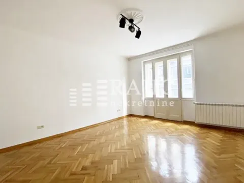 Empty room with parquet flooring and balcony doors. - image 2