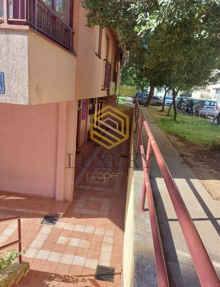 Exterior view of a residential building with an access walkway and sidewalk.