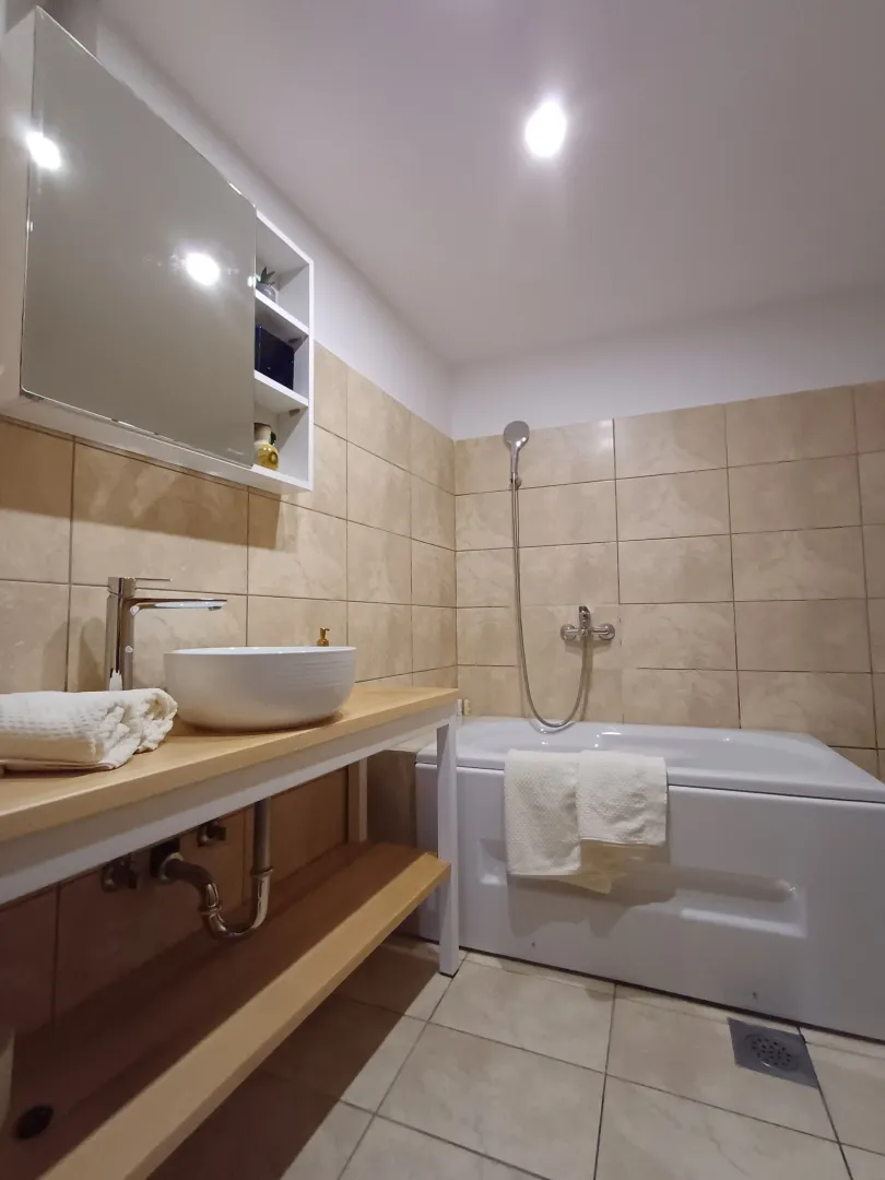 Moderne kupatilo sa umivaonikom, kadom i ormarićem sa ogledalom.