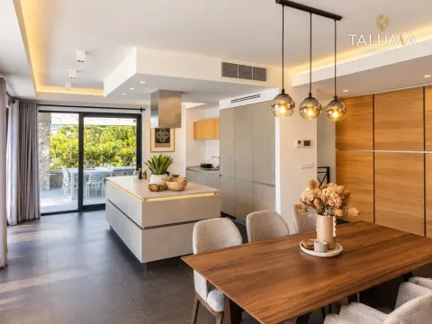 Modern kitchen with an island connected to the dining area and a view of the terrace. - image 16