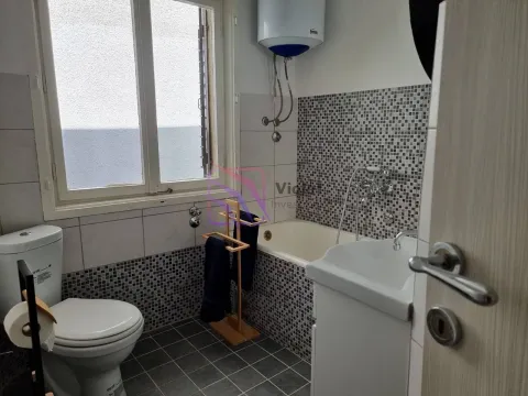 Bathroom equipped with a bathtub, washbasin, toilet, and a window. - image 17