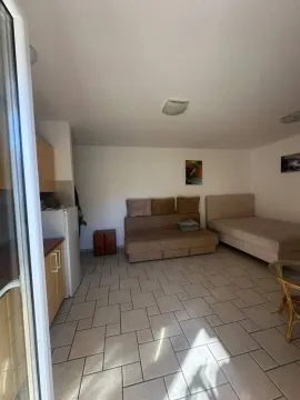 Pogled na dnevni boravak sa krevetom i kuhinjskim elementima. - image 6