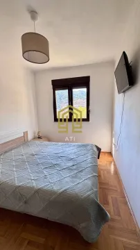 Namještena spavaća soba sa bračnim krevetom, prozorom i televizorom na zidu. - image 7