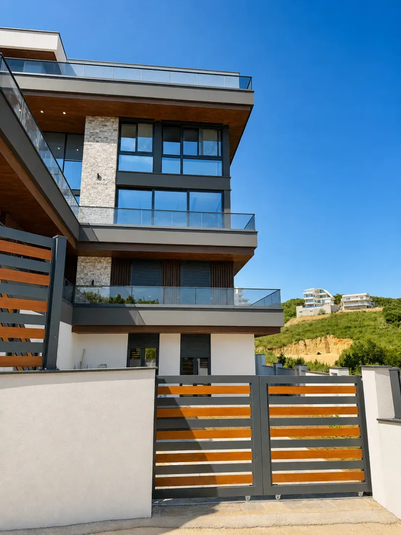 Exterior of a modern residential building with a gate and terraces.