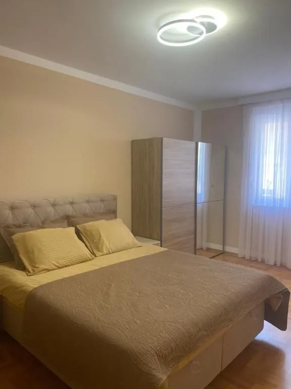 Namještena spavaća soba sa bračnim krevetom i ormarom.