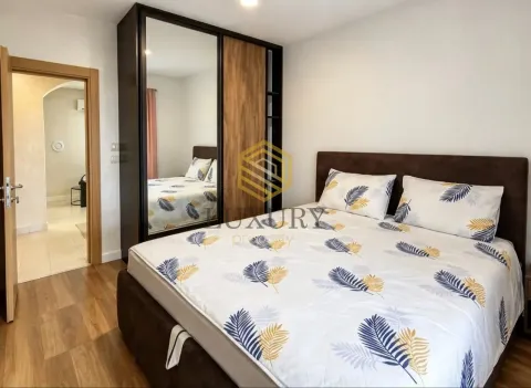 Furnished bedroom with a double bed, large wardrobe, and a view of the bathroom. - image 13