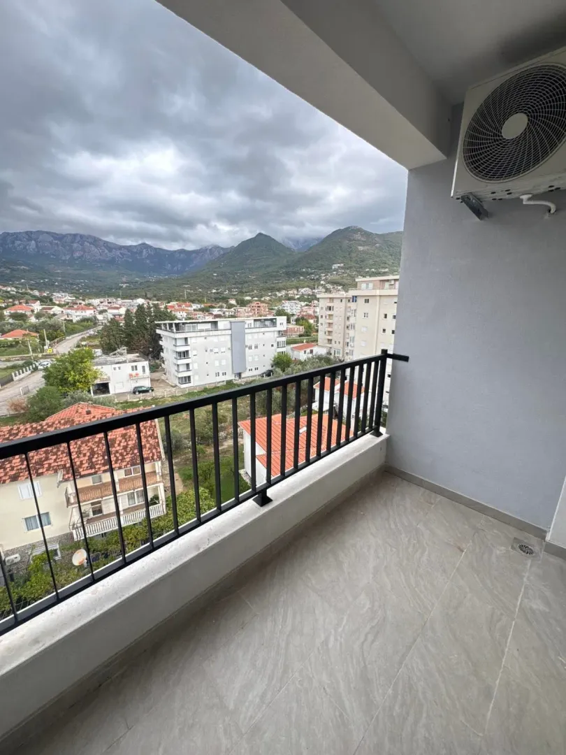 Covered balcony with a view of the city and mountains.