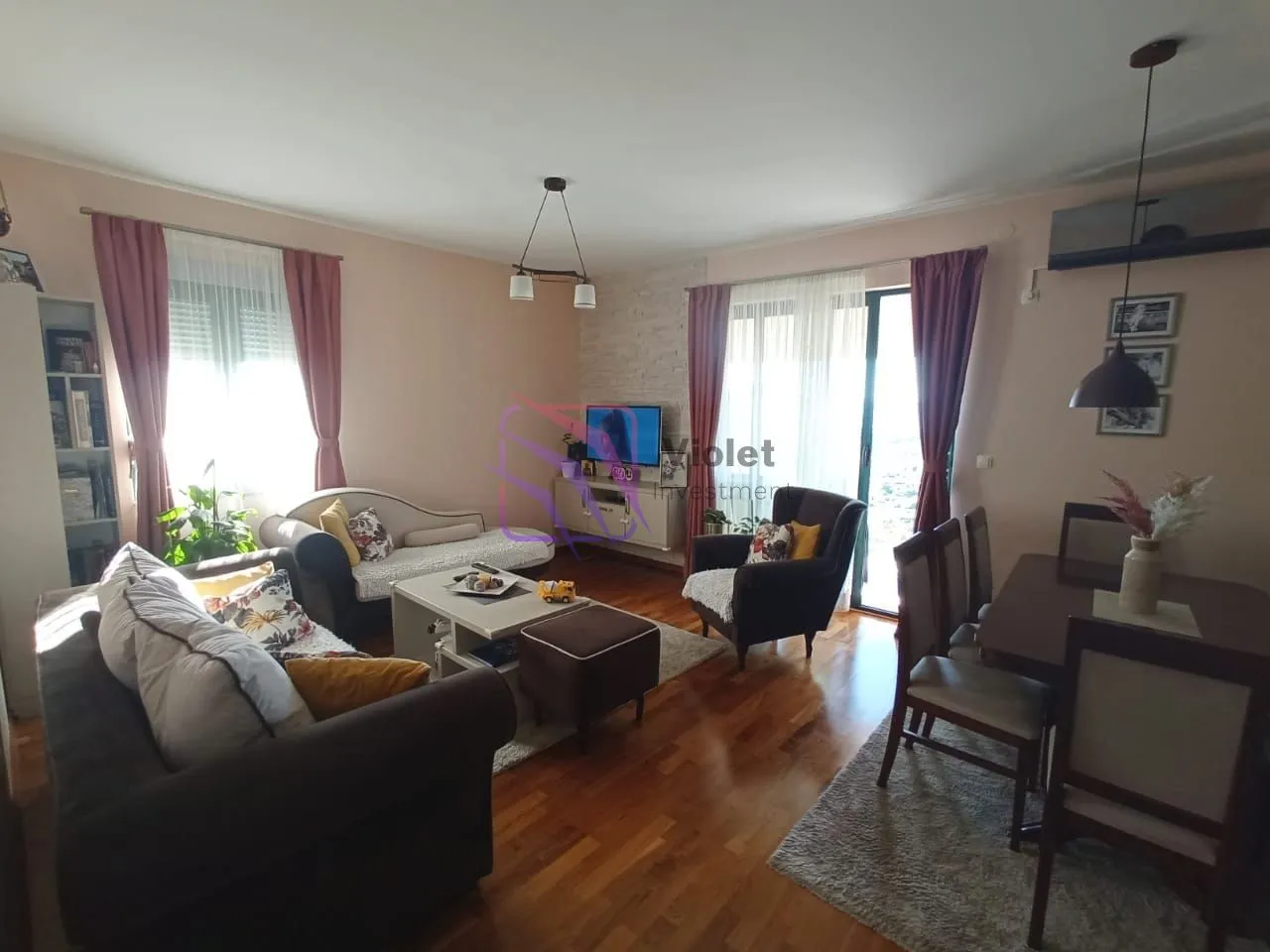 Prostrani dnevni boravak sa trpezarijom i garniturom za sedenje.