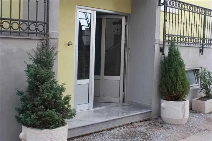 Building entrance with stairs and decorative potted plants.