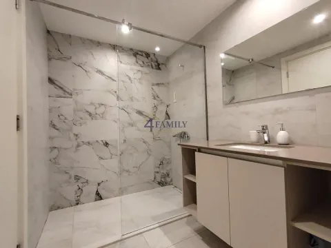 Modern bathroom with a glass-partition shower cabin and vanity sink. - image 13