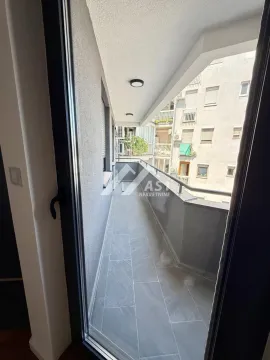 Dugačak popločani balkon sa pogledom na susedne zgrade. - image 10