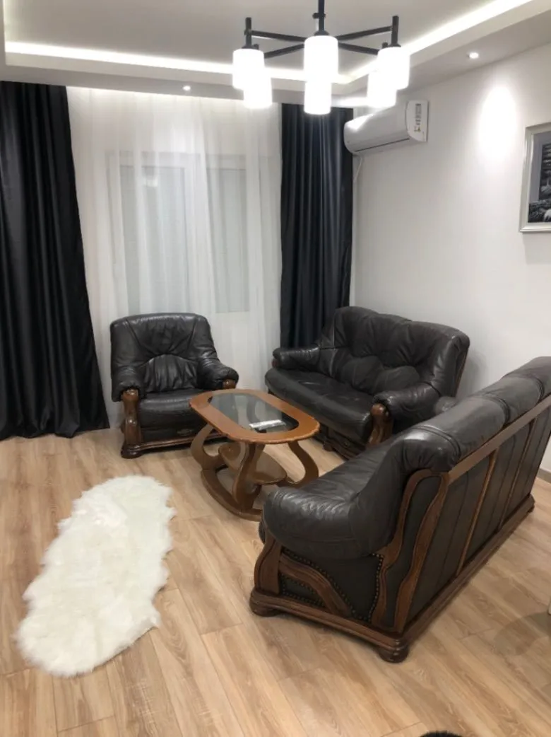Living room with dark leather furniture and a wooden coffee table.
