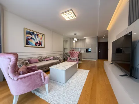 Prostrani dnevni boravak sa garniturom, foteljama, TV-om i otvorenom kuhinjom u pozadini. - image 2