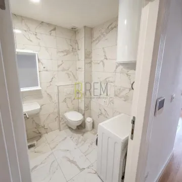 Moderne kupatilo sa bijelim sanitarijama i mermernim pločicama. - image 6
