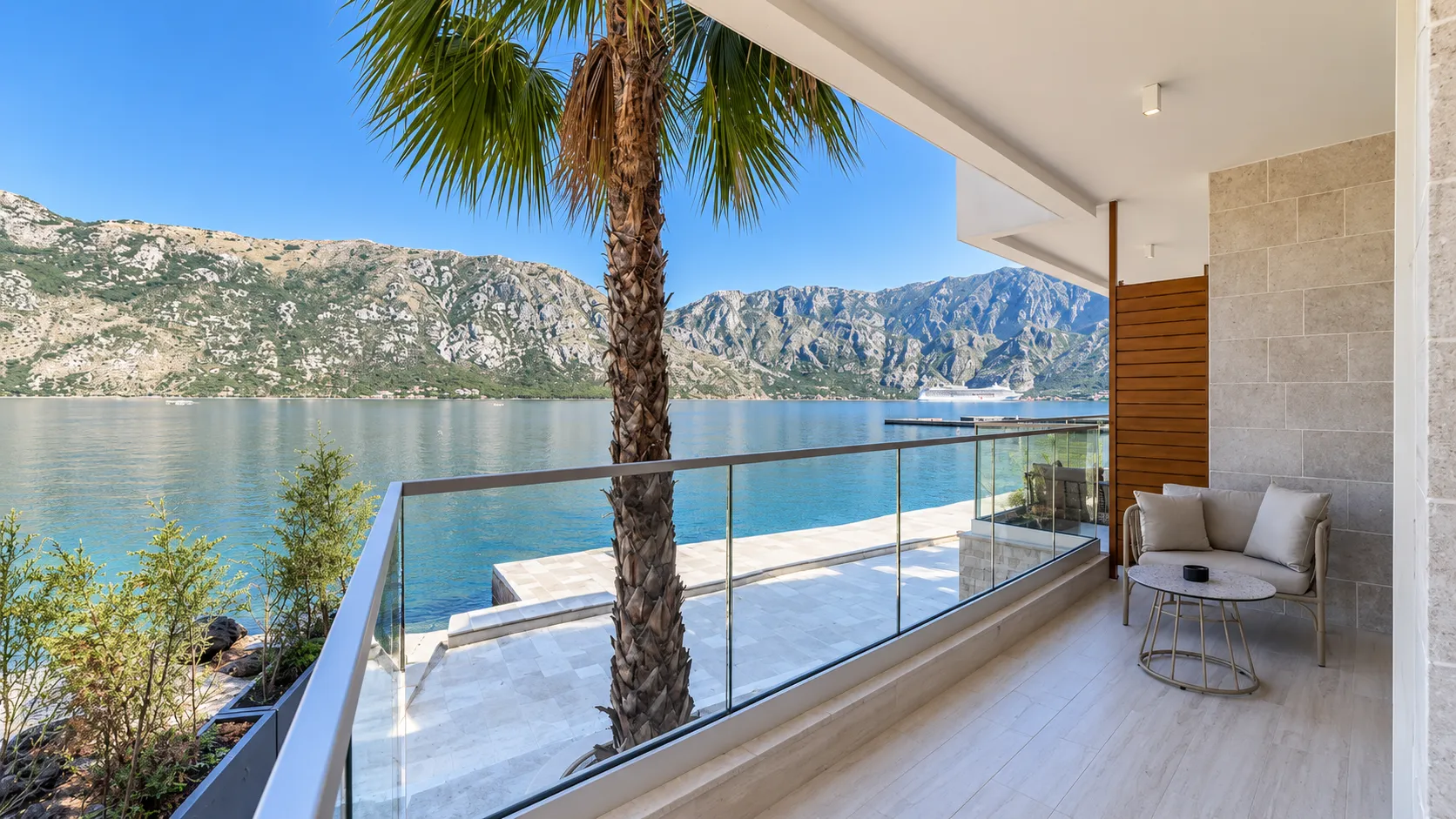 Terrace with seating furniture and a view of the sea and mountains.