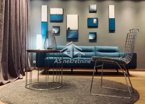 Living room with a blue sofa and decorative paintings on the wall. - image 2