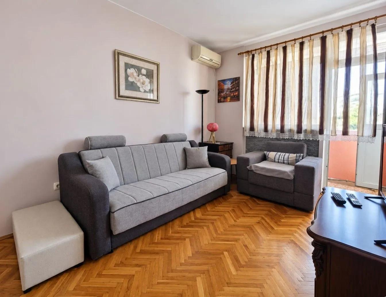 Living room with a sofa set and wooden parquet flooring.