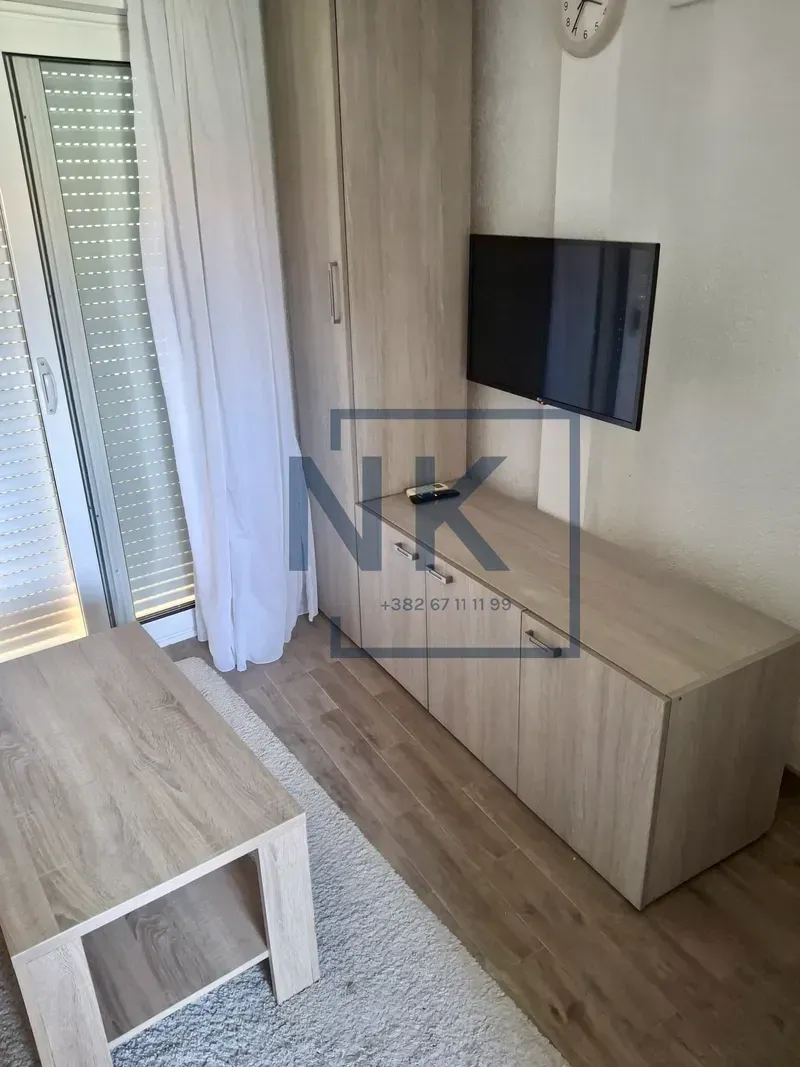 Living room with wooden furniture and a wall-mounted TV.