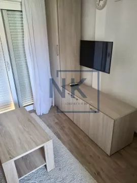 Living room with wooden furniture and a wall-mounted TV. - image 5