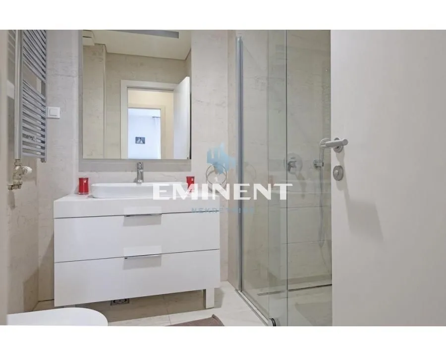 Modernly equipped bathroom with a washbasin and a walk-in shower.