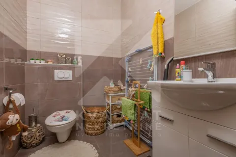 Kupatilo sa umivaonikom, WC šoljom i pločicama u braon tonovima. - image 23